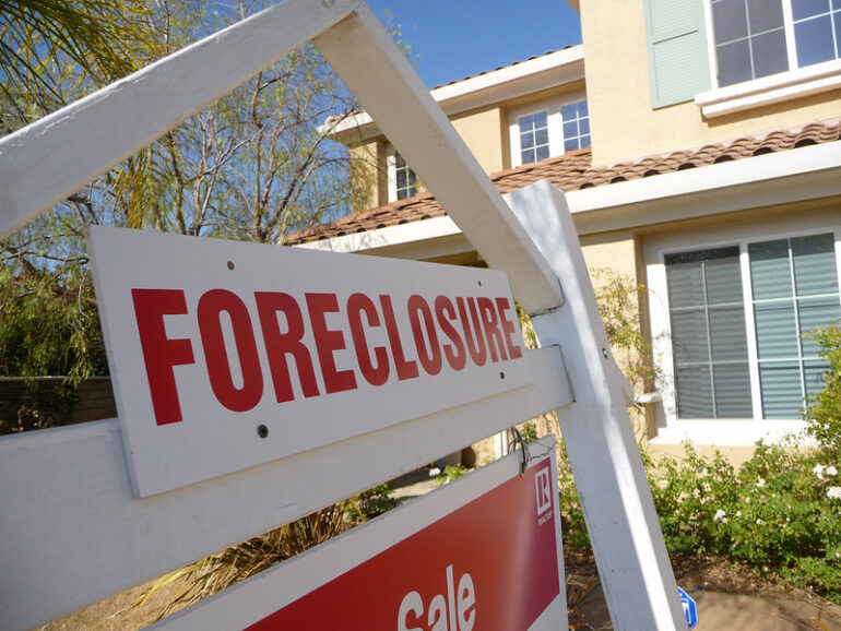 a foreclosure sign in front of a house
