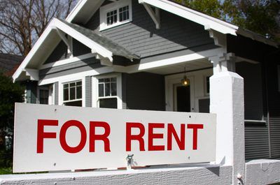 a For Rent sign in front of a house