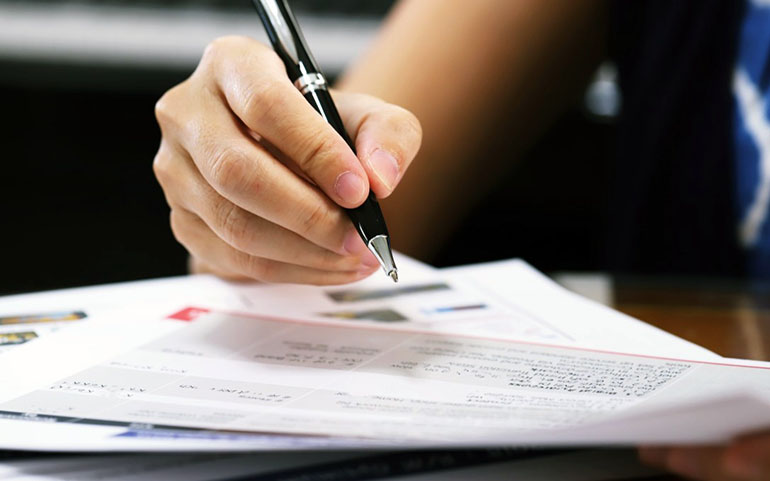 woman signing legal documents to take ownership of the house she has inherited