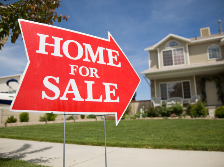 a home for sale sign in a front yard