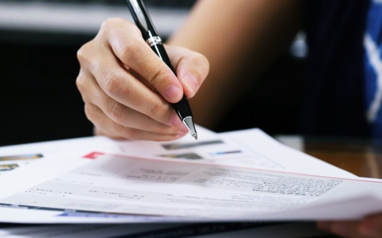 woman signing a mortgage refinance document