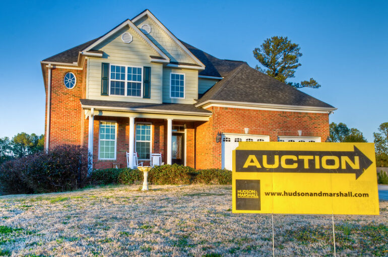 auction sign in front of foreclosed home