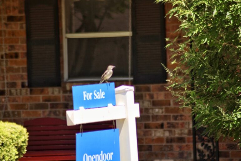 a real estate For Sale sign on a home that's been for sale for many months