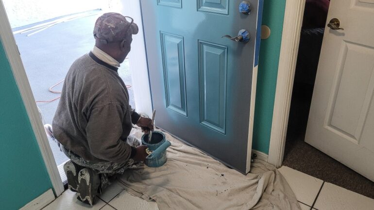 man painting a front door